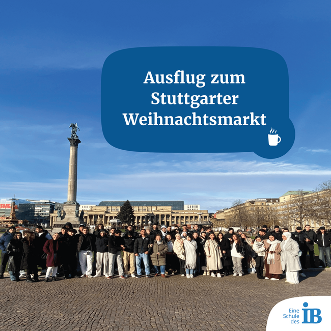 Eine große Gruppe steht vor der Stuttgarter Weihnachtsmarkt-Kulisse mit einer Säule und historischem Gebäude.