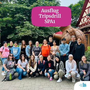 Eine Gruppe von Menschen posiert fröhlich vor einer Attraktion im Freizeitpark Tripsdrill während eines Ausflugs.