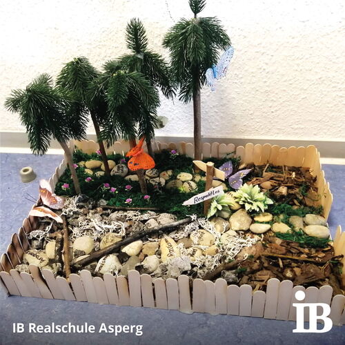 Ein Miniaturwaldmodell zeigt Bäume, Schmetterlinge und ein Schild mit der Aufschrift "Respektlos" in einem Wettbewerb.