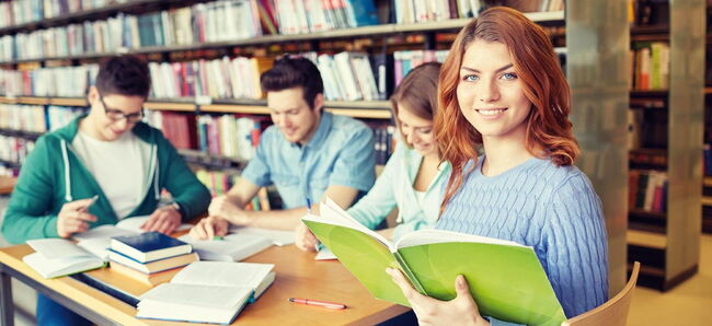 Vier Schüler:innen lernen in einer Bibliothek