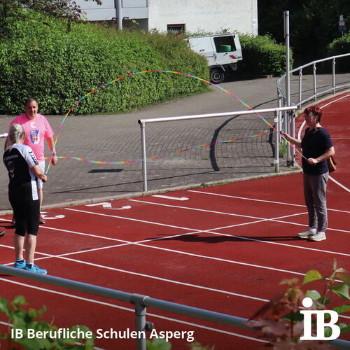 Drei Personen stehen auf einer Laufbahn und springen Seil bei einem sportlichen Event der IB Berufliche Schulen Asperg.