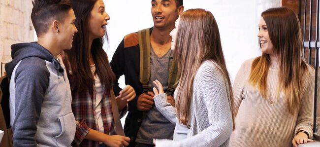 5 Schüler:innen lachen zusammen