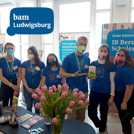 Eine Gruppe von Menschen in blauen T-Shirts steht bei einer Messe in Ludwigsburg an einem Stand mit Tulpen.