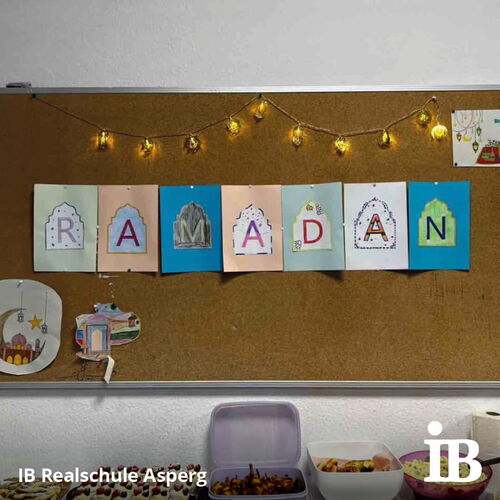 Ein dekoriertes Brett mit dem Schriftzug "RAMADAN" und Lichterketten kündigt ein Fastenbrechen an.