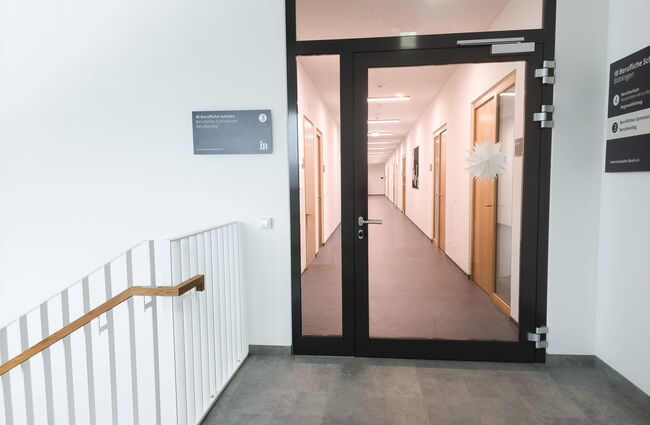 Der Eingang zum Flur im 3. OG zeigt moderne, helle Türen und einladende Beschilderung der IB Beruflichen Schulen.
