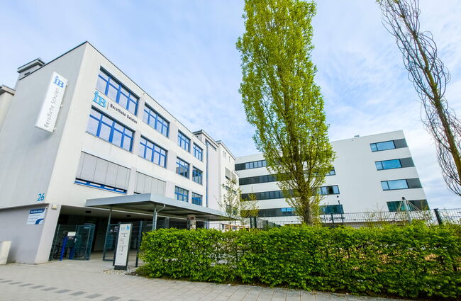 Moderne Neubau mit hellen Fassaden und begrünten Bereichen vor der Beruflichen Schule.