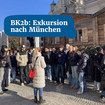 Eine Gruppe von Jugendlichen auf einer Exkursion in München versammelt sich vor einem historischen Gebäude.
