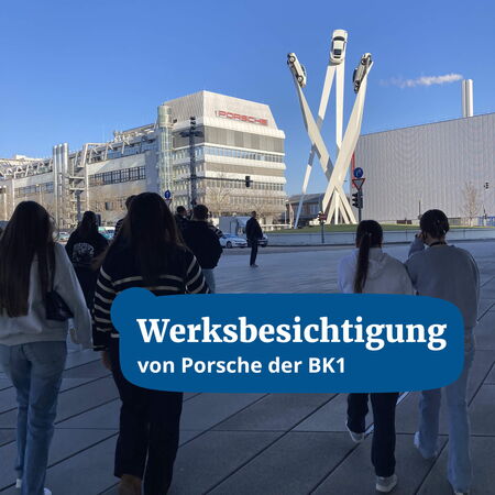 Eine Gruppe von Menschen nähert sich dem Porsche-Werk mit einer markanten Skulptur, die Autos zeigt.