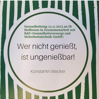 Ein kreisförmiges Poster kündigt den Gesundheitstag am 23.11.2023 in Heilbronn mit einem Zitat von Konstantin Wecker an.