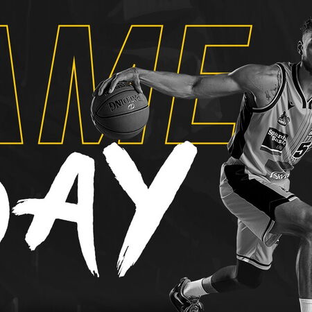 Ein Basketballspieler der MHP Riesen Ludwigsburg dribbelt dynamisch vor einem großen "Game Day"-Schriftzug.