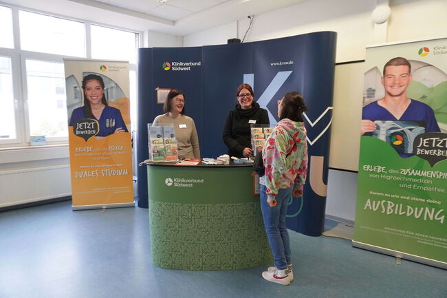 Eine Frau informiert sich an einem Messestand des Klinikverbunds Südwest über duale Studienmöglichkeiten.