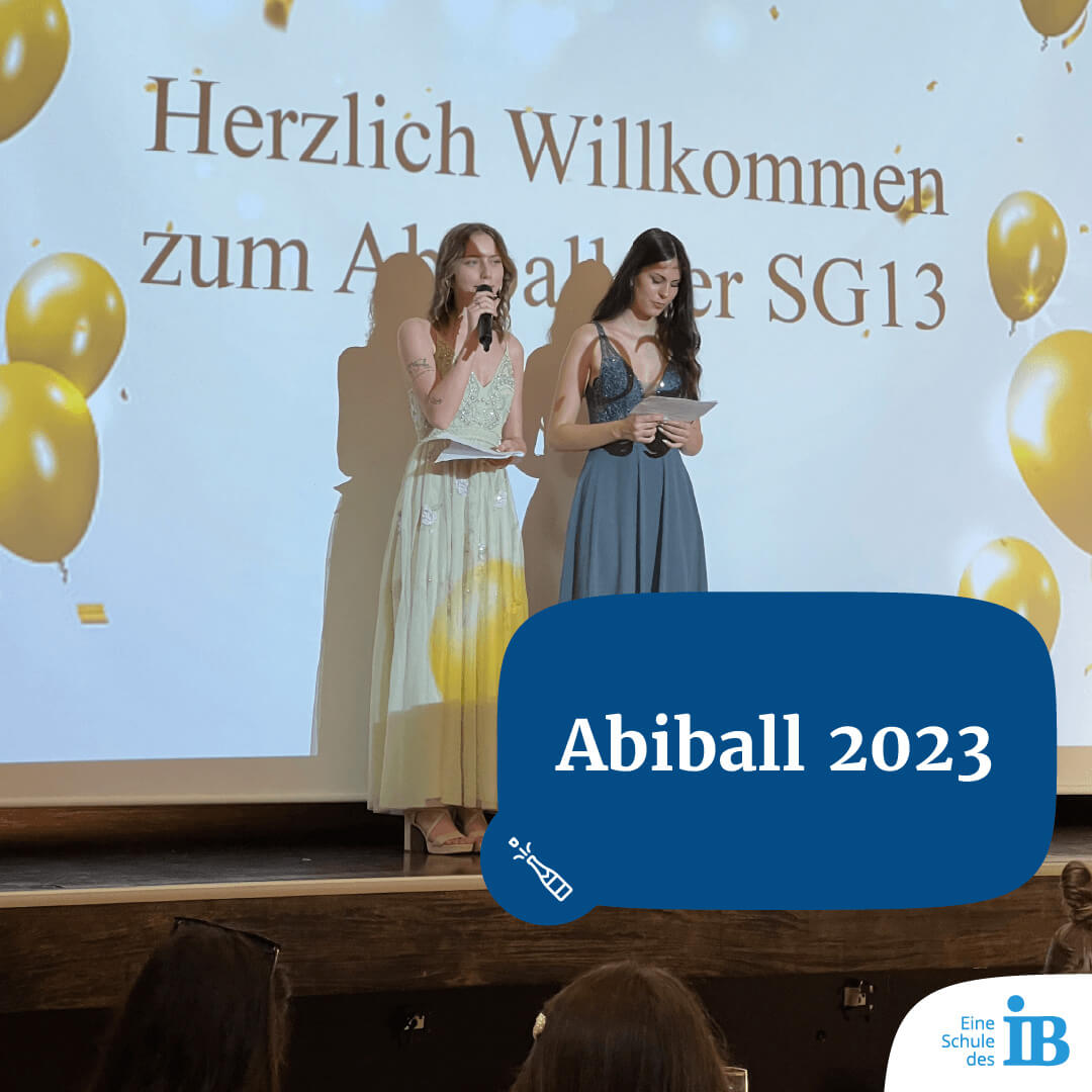 zwei junge Frauen moderieren den Abschlussball der SG13 2023 auf der Bühne