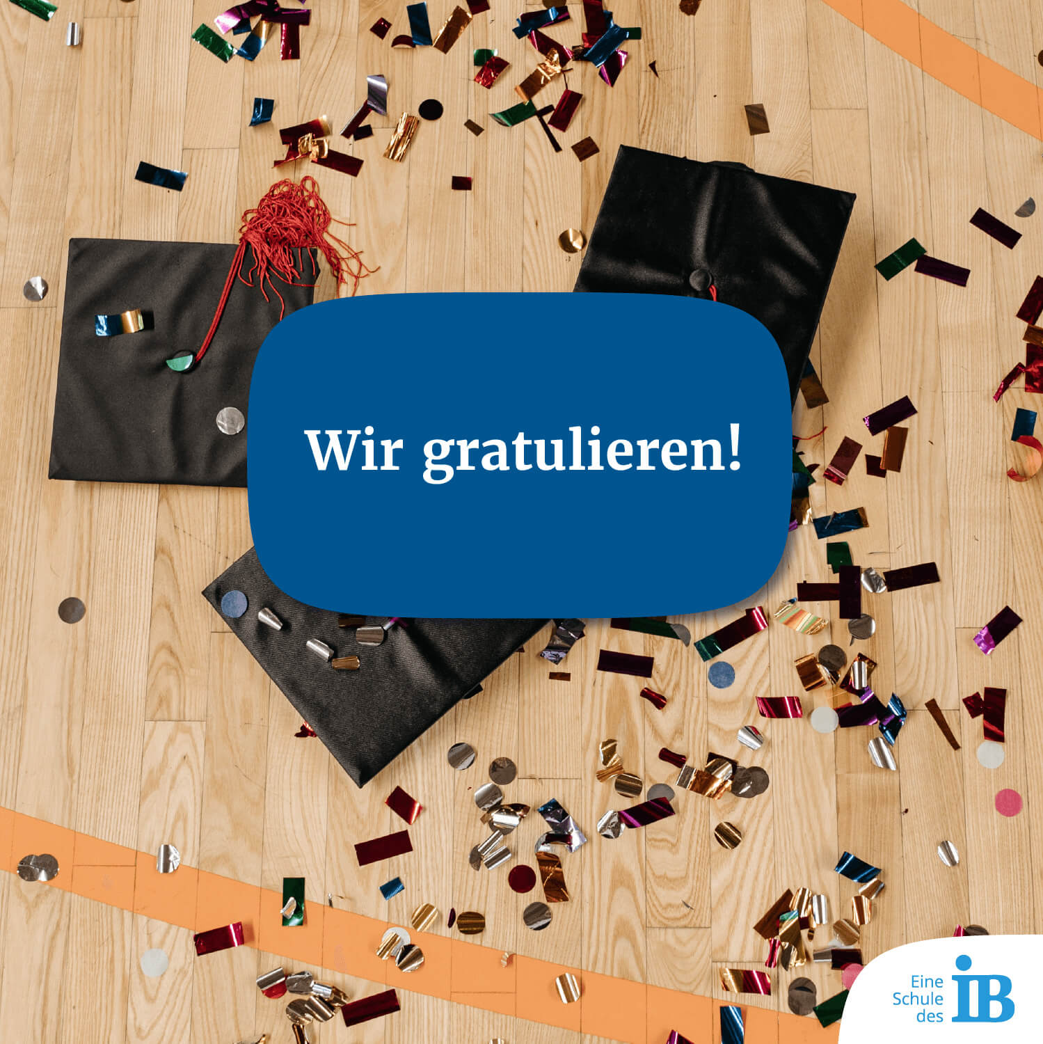 Wir gratulieren! Konfetti und Abschlusshüte liegen auf Parkettboden