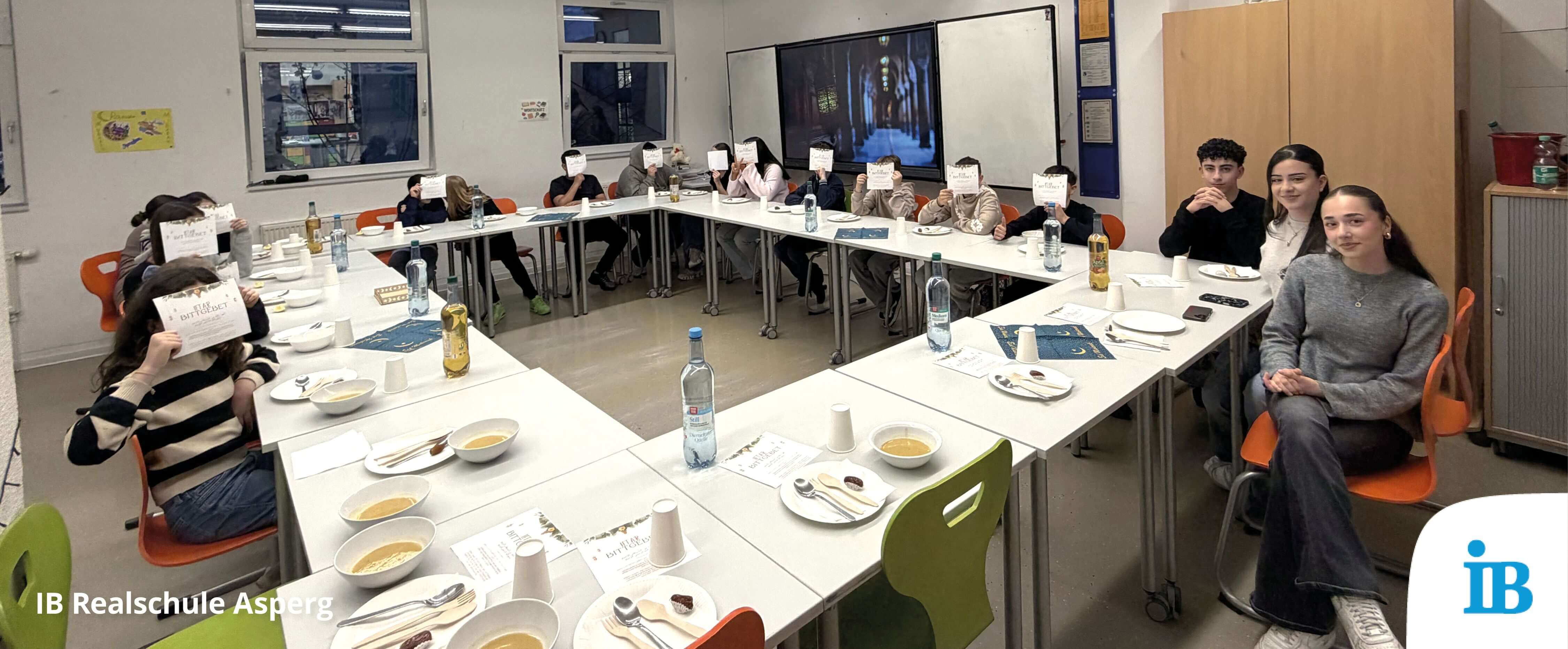 Schüler sitzen an einem Tisch bei einem Iftar-Essen, während sie sich auf das Fastenbrechen vorbereiten.