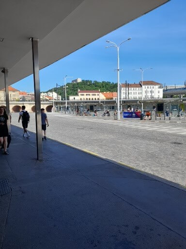 Eine belebte Straße mit Menschen, die an einem sonnigen Tag in der Stadt spazieren gehen.