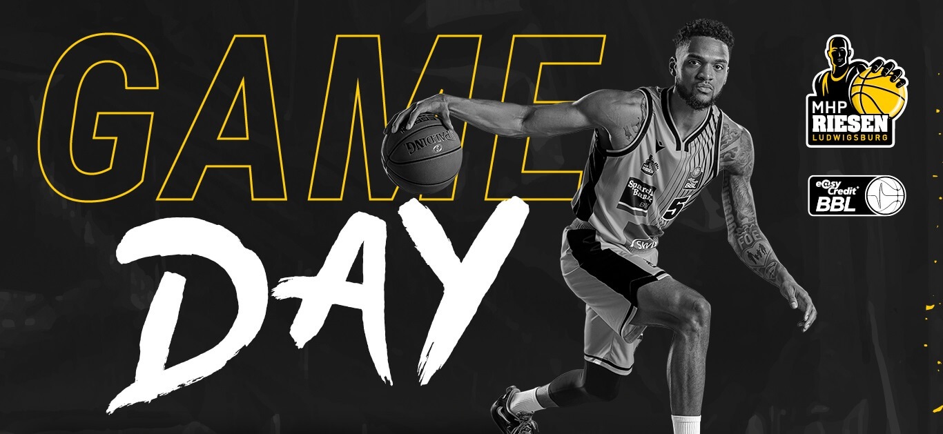 Ein Basketballspieler der MHP Riesen Ludwigsburg dribbelt dynamisch vor einem großen "Game Day"-Schriftzug.
