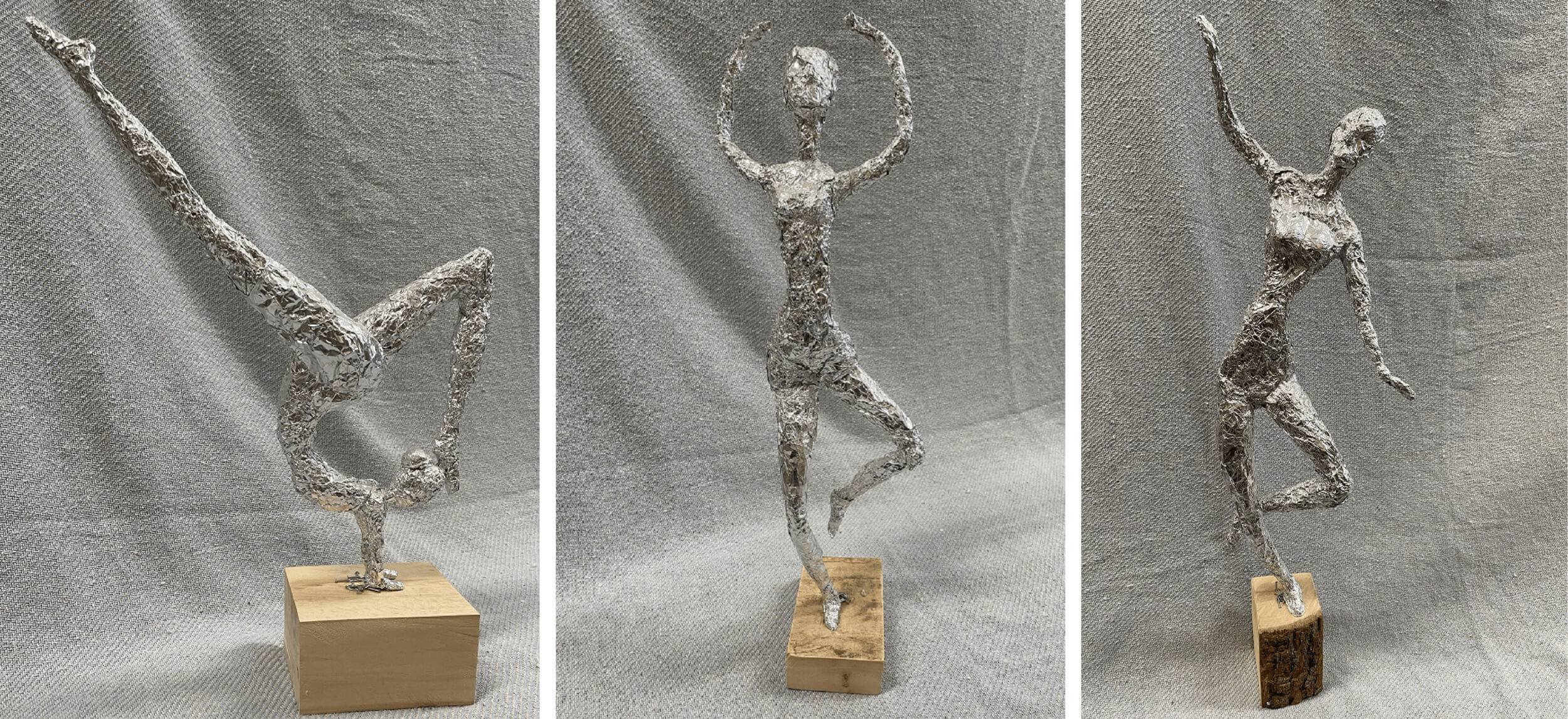 Drei kunstvolle Figuren aus Aluminiumfolie zeigen ausdrucksstarke Tanzposen auf Holzsockeln vor einem grauen Hintergrund.