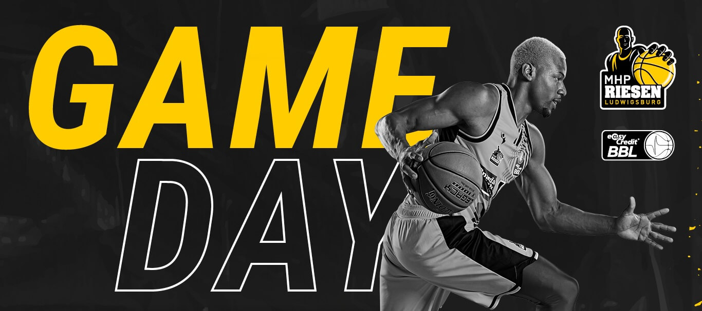 Ein Basketballspieler der MHP RIESEN dribbelt kraftvoll, während "Game Day" in großen gelben Buchstaben erscheint.