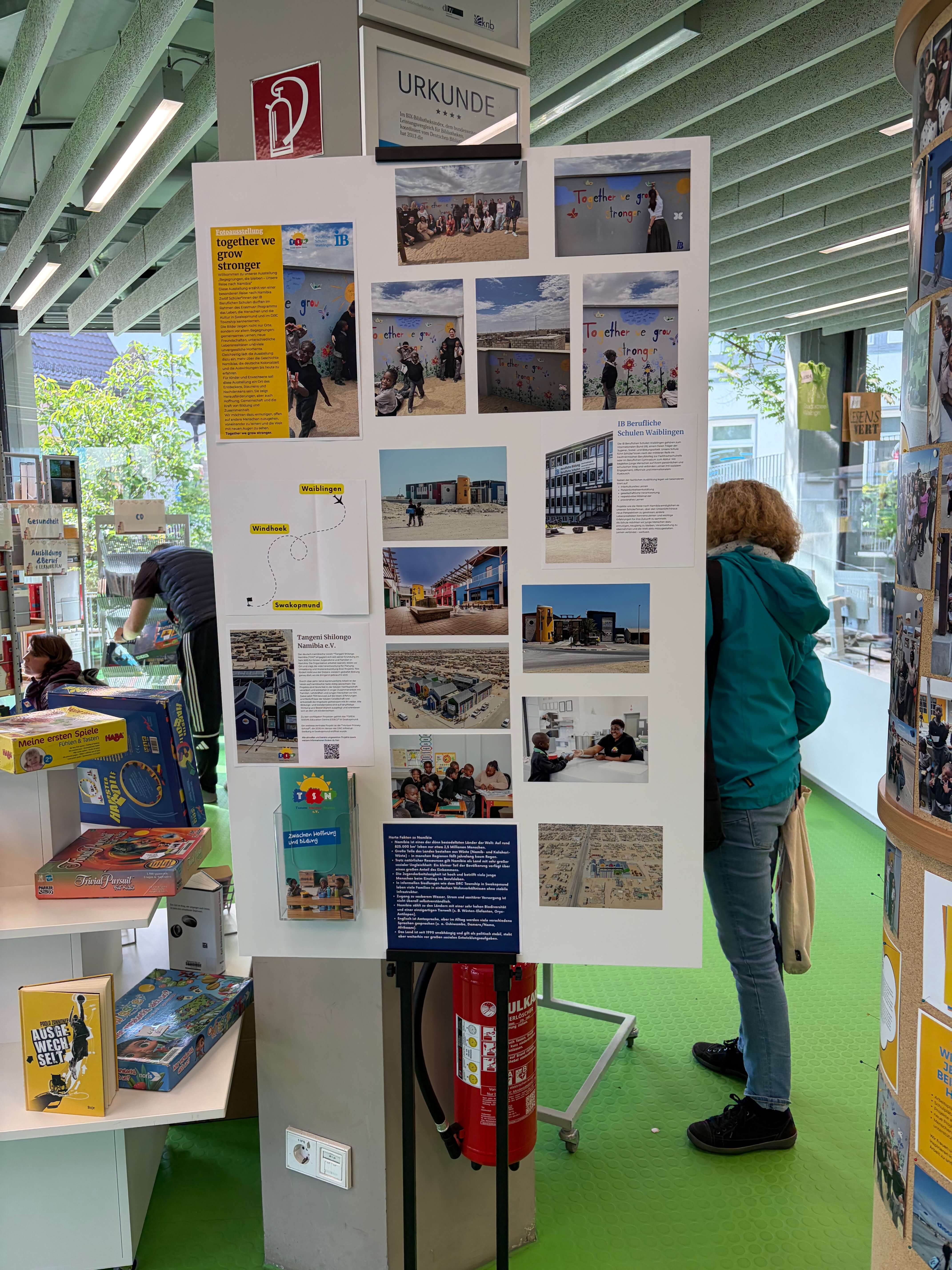 Eine Ausstellung mit Bildern und Informationen über das Projekt „Together We Grow Stronger“ im Bibliotheksraum.