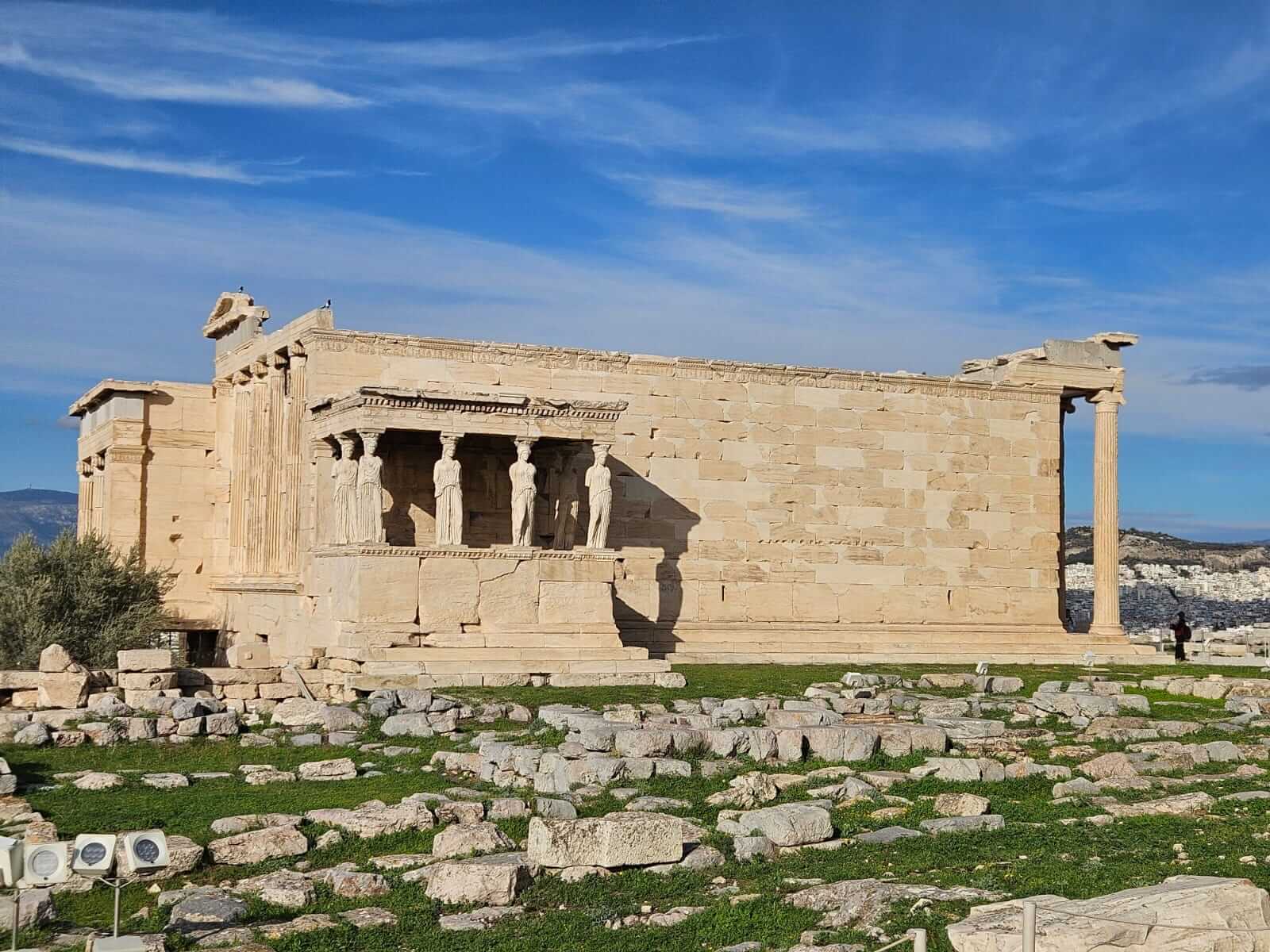 Der Erechtheion-Tempel auf der Akropolis zeigt seine ikonischen Karyatiden bei blauem Himmel im Novemberlicht.