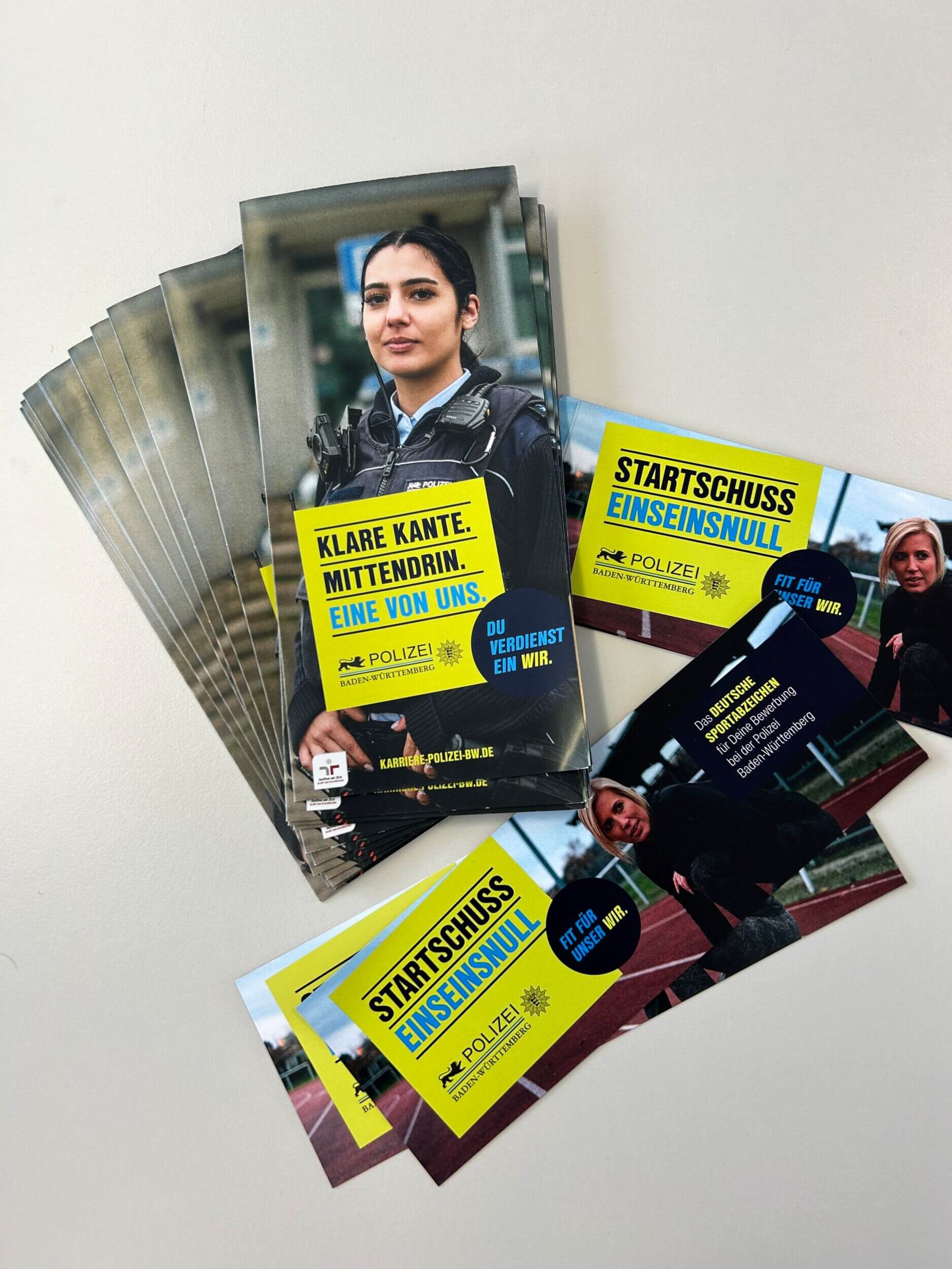 Ein Stapel Flyer der Polizei Baden-Württemberg wirbt für Karrieremöglichkeiten mit dem Slogan "Klare Kante. Mittendrin."