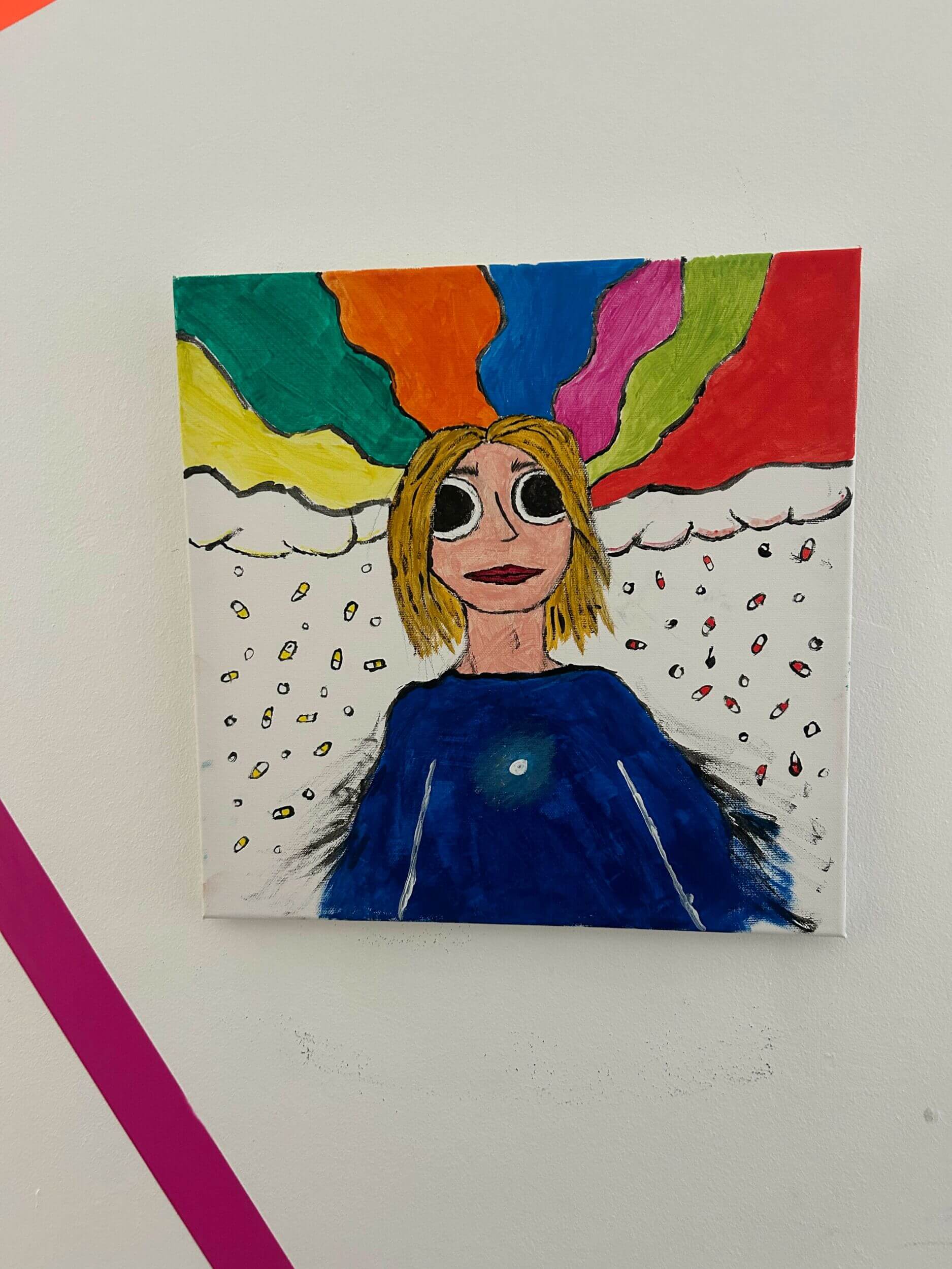 Ein buntes Gemälde zeigt eine Person mit großen Augen und Regenbogenfarben, die aus dem Kopf strahlen.